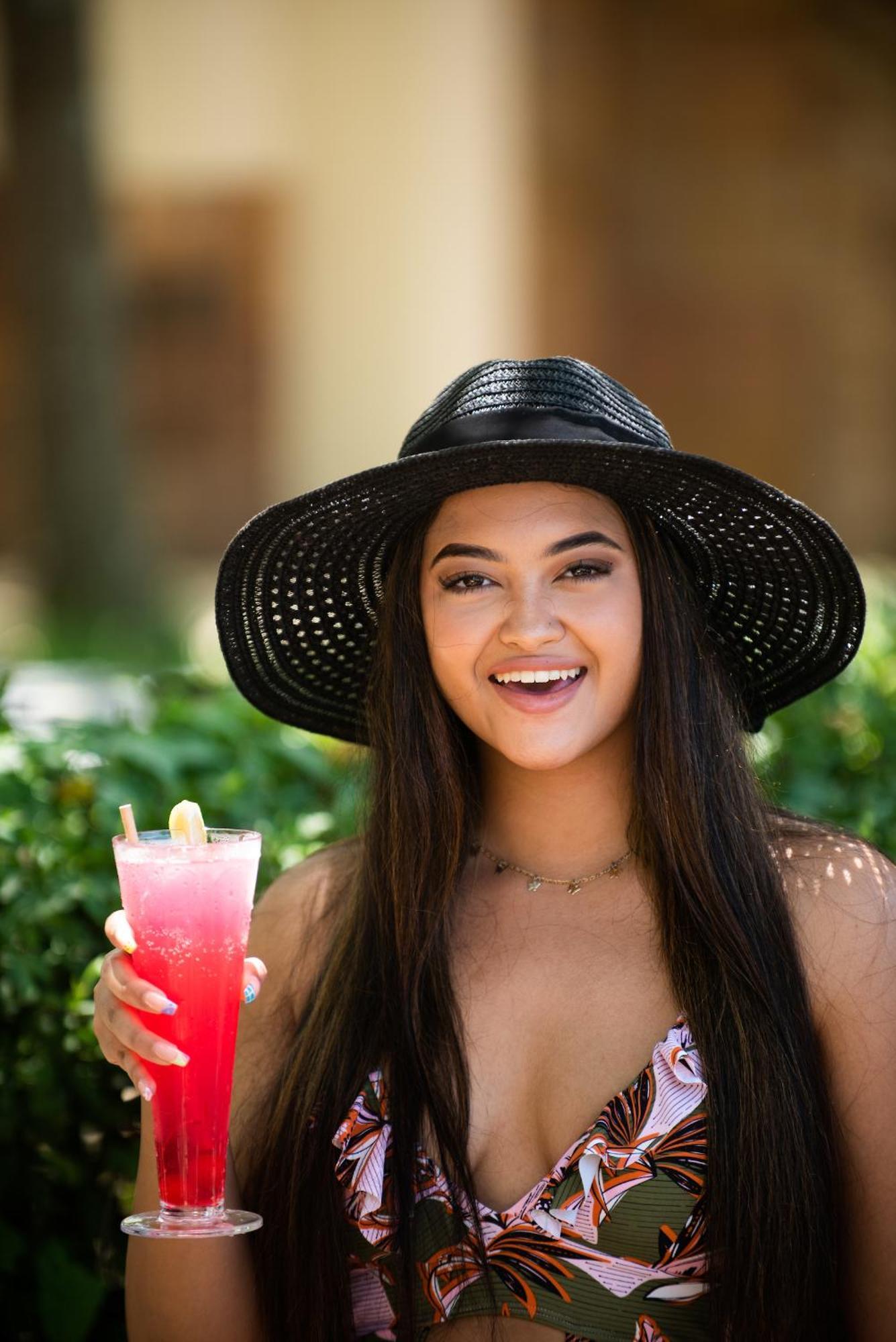 The Capital Zimbali Hotell Ballito Exteriör bild A woman wearing a sun hat
