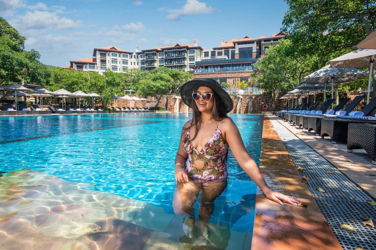 The Capital Zimbali Hotell Ballito Exteriör bild A woman wearing a sun hat
